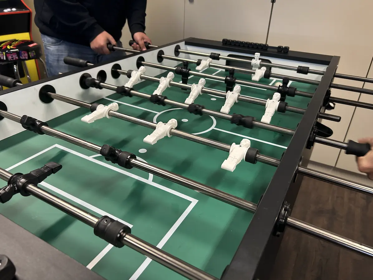 two team members playing table soccer